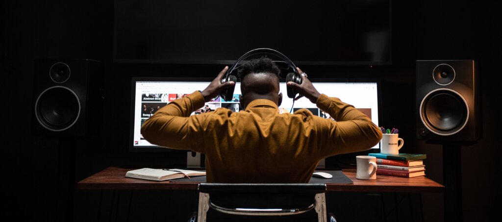 Sound editor at workstation with headphones