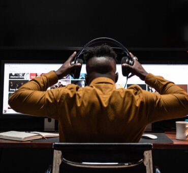 Sound editor at workstation with headphones