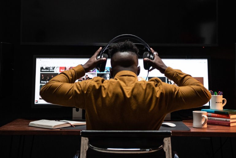 Sound editor at workstation with headphones