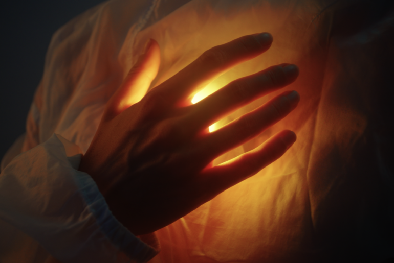 hand on glowing heart